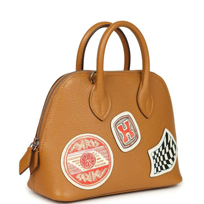 Mini tan leather handbag with two top handles and stitched logo patches