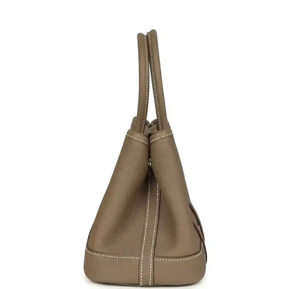Taupe leather mini tote bag with tall handles and side stitched seams