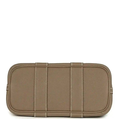 Taupe leather mini tote bag with flat base, stitched panels, and top zipper edge