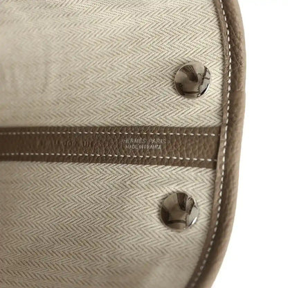 Light interior lining of mini tote bag with snap buttons and Hermes Paris label