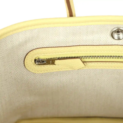 Yellow leather bag interior with zip pocket and silver-tone zipper pull