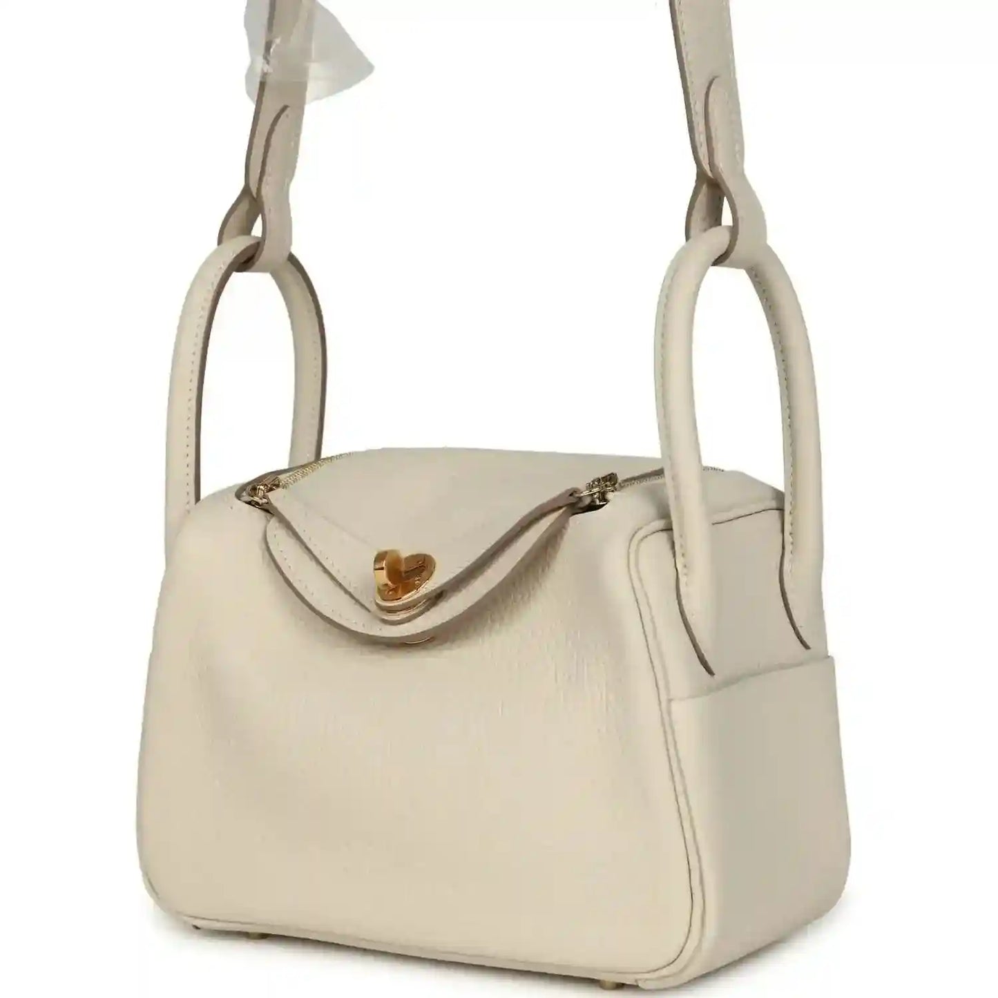 Hermes mini Lindy II bag, pale cream leather, gold clasp detail, three-quarter view