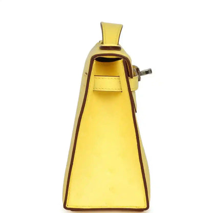 Yellow leather Kelly-style pochette with top handle and open flap pocket view