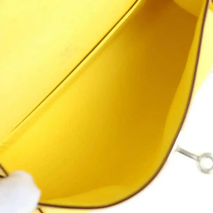Yellow leather pochette interior with curved lining and small hardware edge