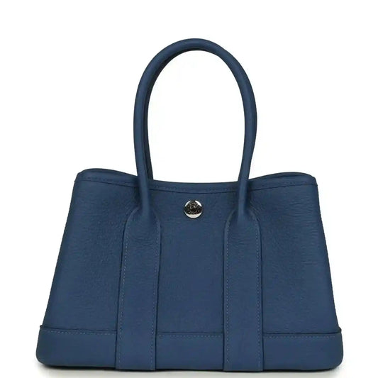 Blue leather tote with curved handles and front gold-tone clasp