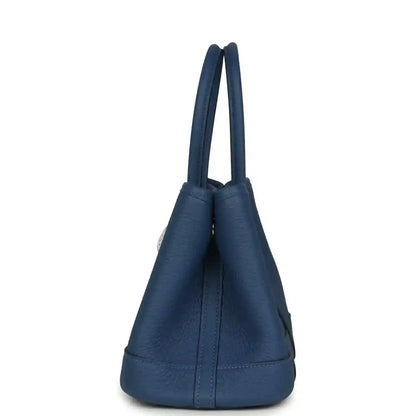 Blue leather tote with short loop handles and rounded bucket shape