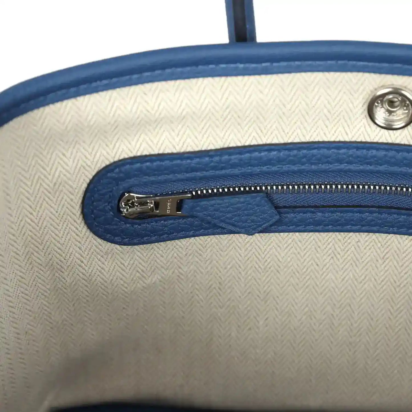 Beige fabric interior with blue zipper track and metal zipper pull