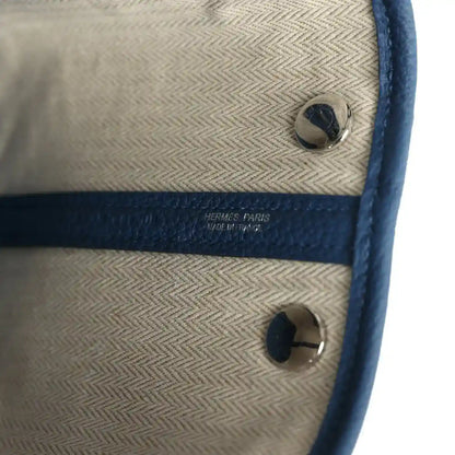 Beige lining with Hermes Paris text and blue leather snap pocket