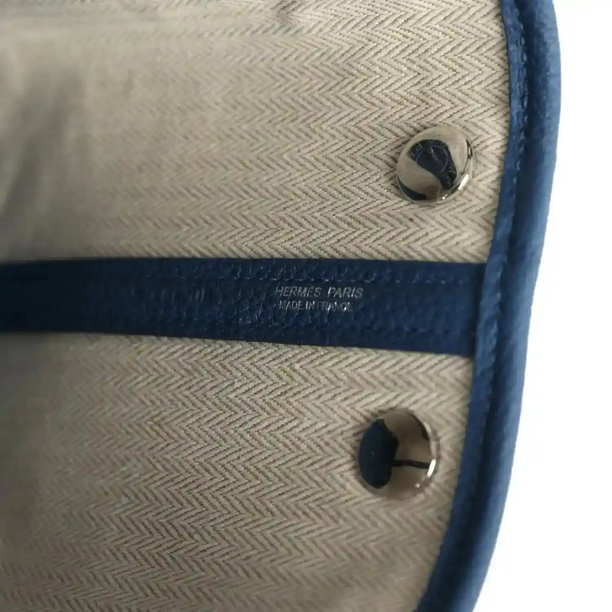 Beige lining with Hermes Paris text and blue leather snap pocket