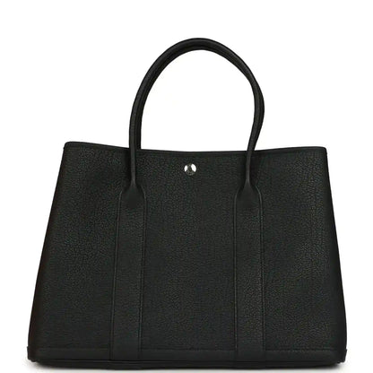 Black leather tote bag with two top handles and center snap button
