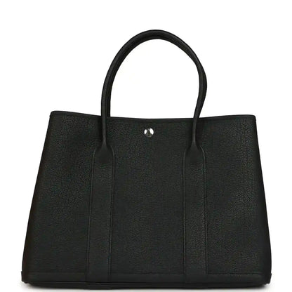 Black leather tote bag with two top handles and center snap button