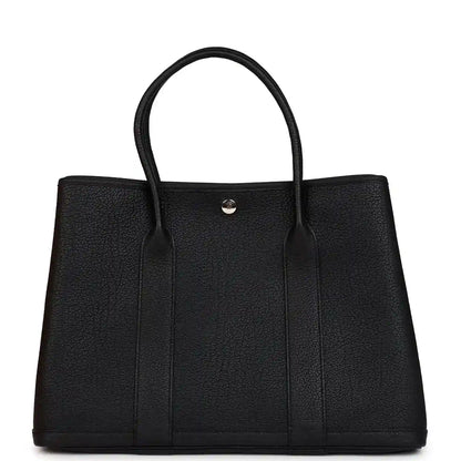 Black leather tote bag with two top handles and center snap closure