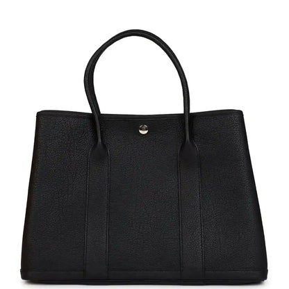 Black leather tote bag with two top handles and center snap closure