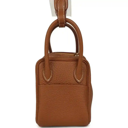 Mini Lindy bag in tan textured leather with dual handles and top clasp