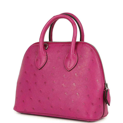 Mini Bolide bag three-quarter view in rose purple ostrich leather with side zip pull.