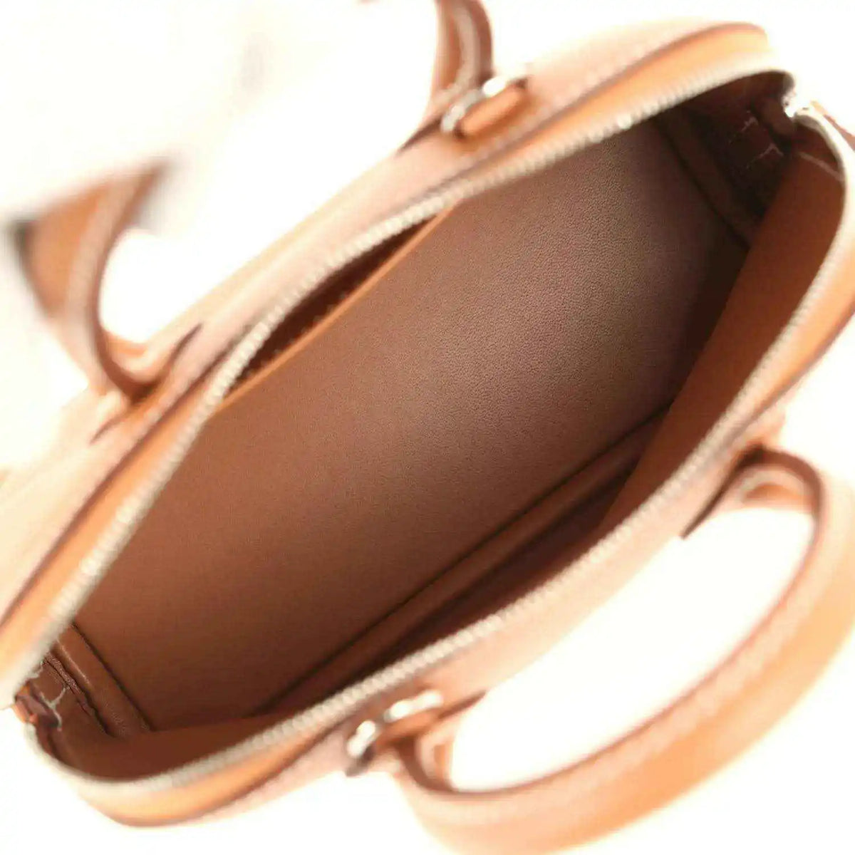 Mini Bolide handbag interior with smooth brown lining and open top zipper edge