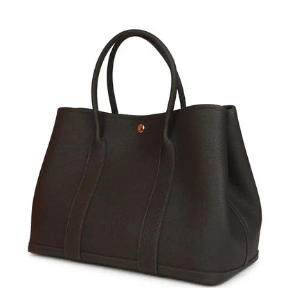 Leather tote bag with top handles and small logo plaque, dark brown, front panel.