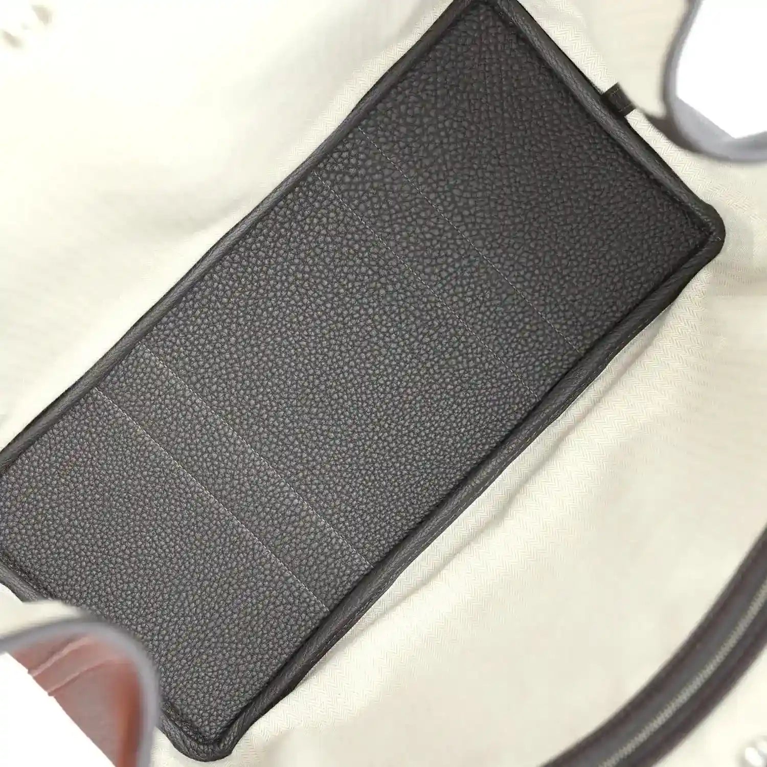 Leather zip pouch insert with dark brown textured surface, flat profile.