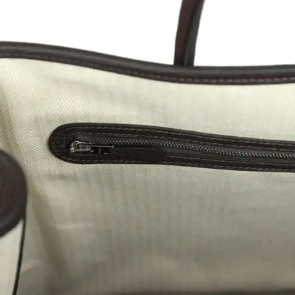 Leather pouch interior with stitched fabric lining and metal zipper track, dark brown edges.