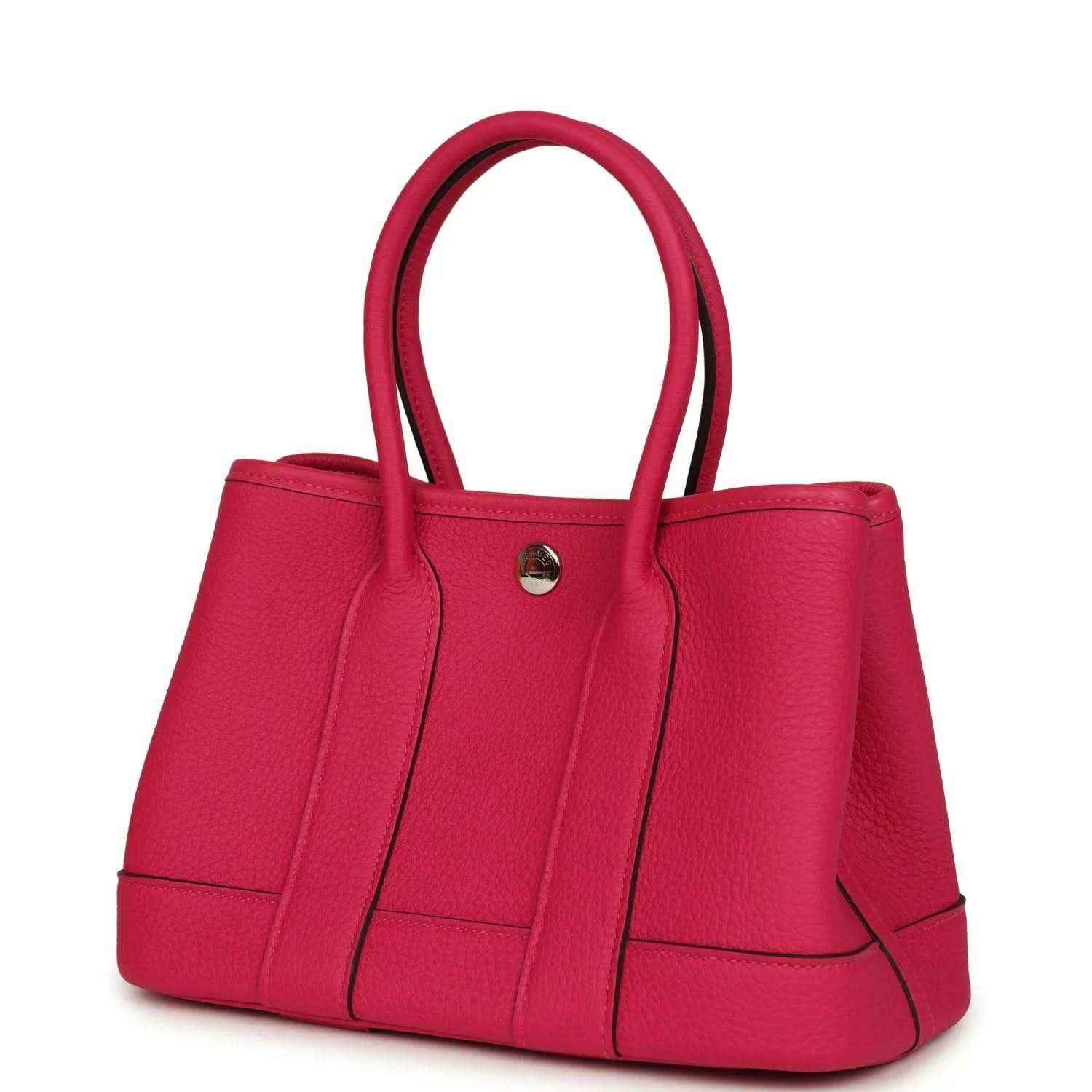 Rose pink leather tote bag with top handles, round metal clasp, and panel detailing