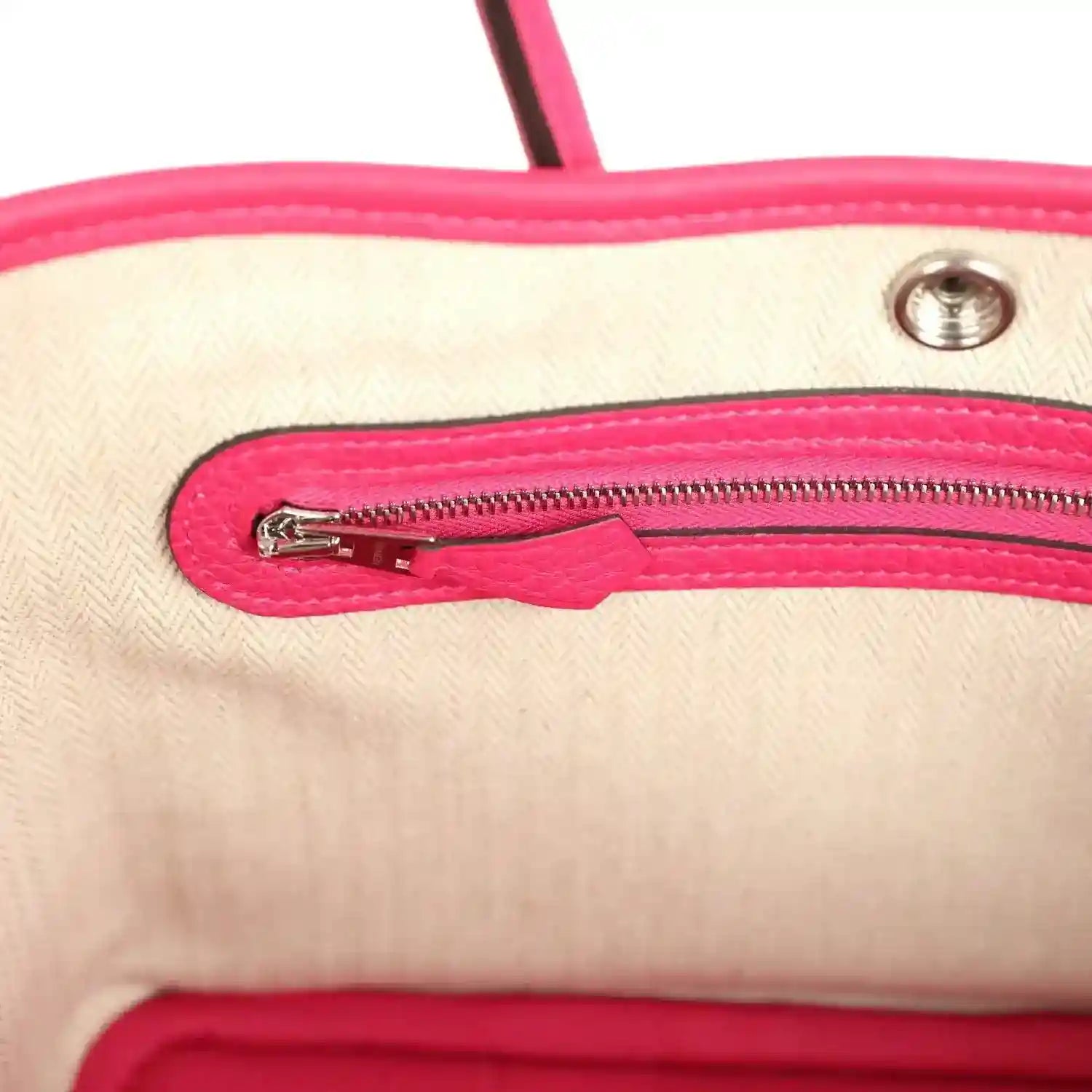 Rose pink leather tote bag interior close-up of zipper with metal pull tab