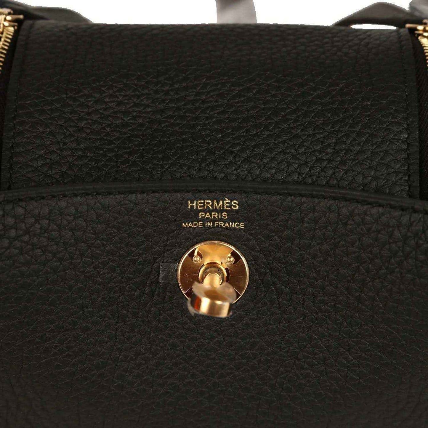 Hermes Mini Lindy II bag closeup: black textured leather with gold turn-lock and Hermes Paris text