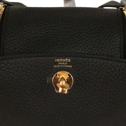 Hermes Mini Lindy II bag closeup: black textured leather with gold turn-lock and Hermes Paris text