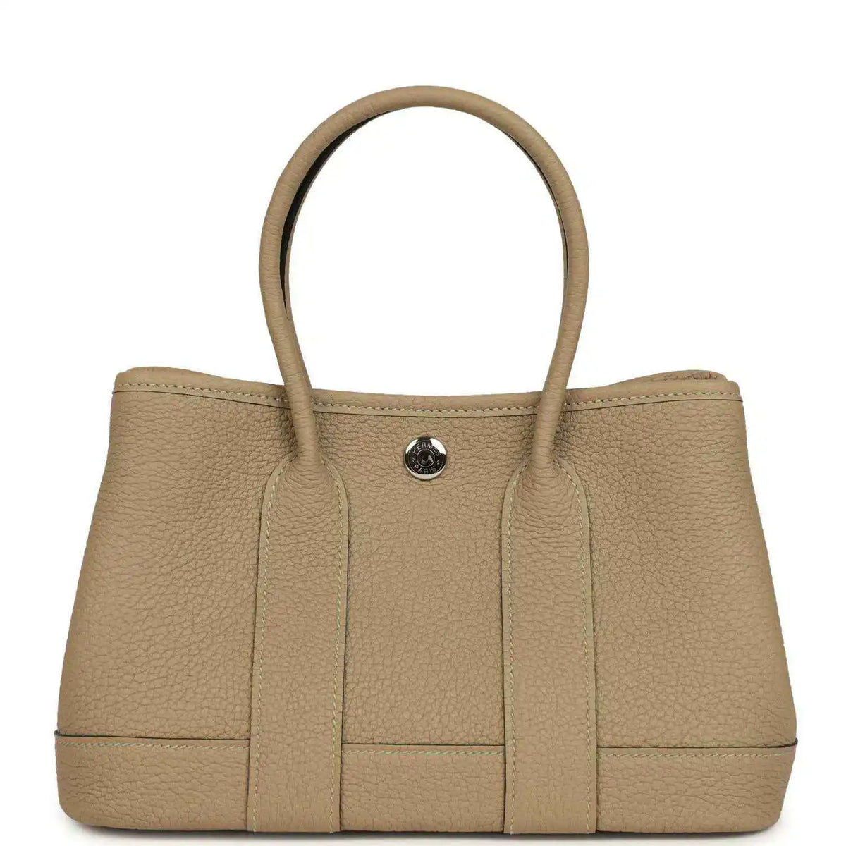Trench-colored leather tote with top handles and round front snap closure