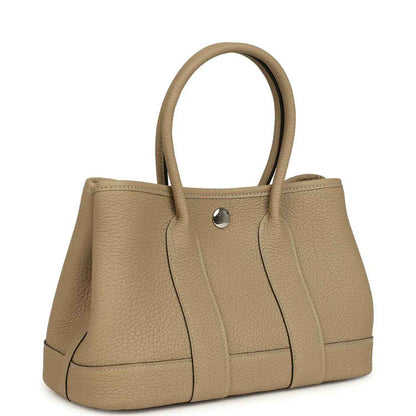 Trench leather tote with top handles and front snap closure