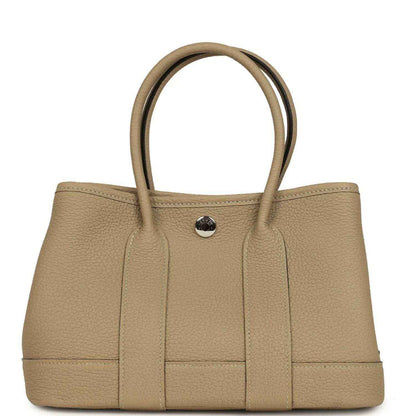 Trench leather tote with top handles and front button snap closure