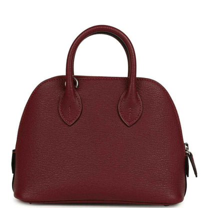 Mini leather handbag with top handles and side zipper pulls in deep red