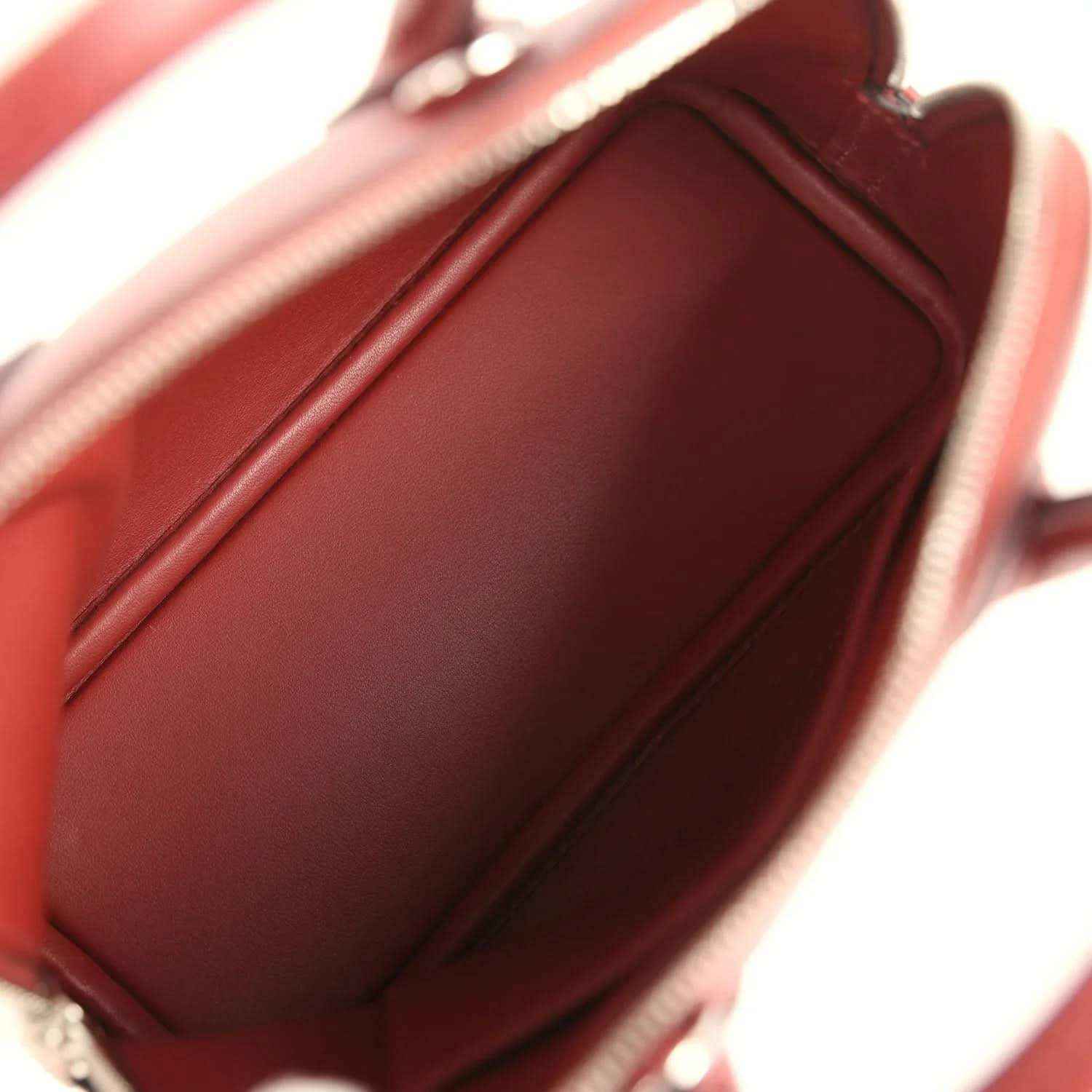 Mini leather handbag interior with smooth lining and stitched seams in deep red