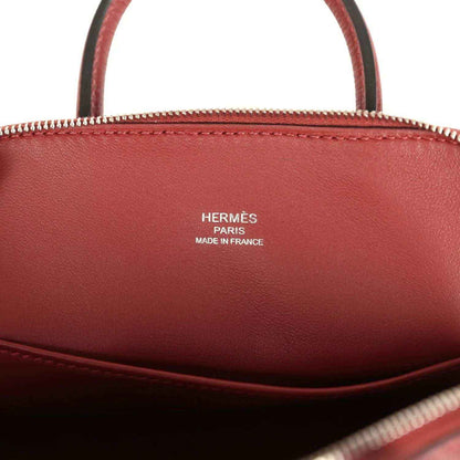 Mini leather handbag interior with HERMÈS Paris Made in France stamp in deep red