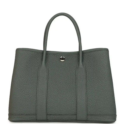 Structured leather tote bag with top handles and snap front tab, textured dark green