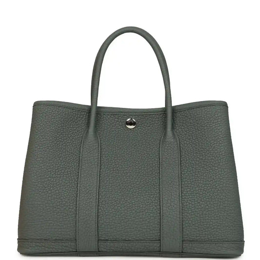 Structured leather tote bag with top handles and snap front tab, textured dark green