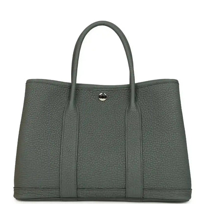Structured leather tote bag with top handles and snap front tab, textured dark green