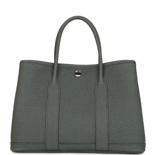 Structured leather tote bag with top handles and snap front tab, textured dark green