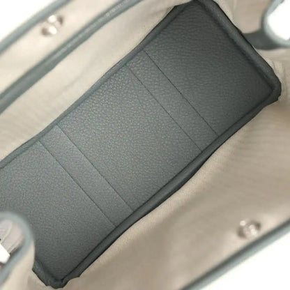Leather tote interior lining with partitioned pockets, dark green panels and light lining