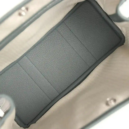 Leather tote interior lining with partitioned pockets, dark green panels and light lining