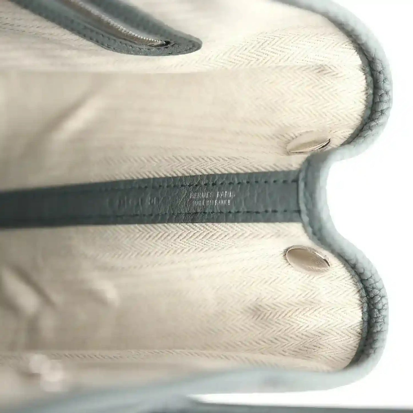 Leather tote interior with embossed logo detail and stitched edges, light lining