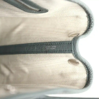 Leather tote interior with embossed logo detail and stitched edges, light lining