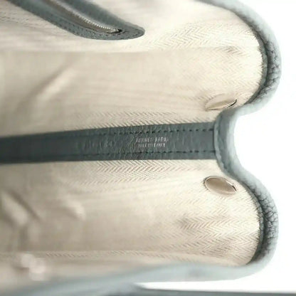 Leather tote interior with embossed logo detail and stitched edges, light lining