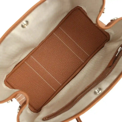 Brown leather interior pocket with stitched seams inside the tote