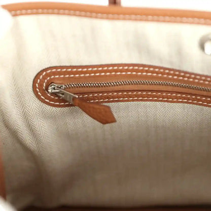 Tote interior with zipper pull and brown leather trim on the pocket