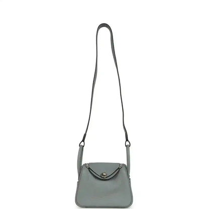 Mini crossbody handbag with thin adjustable strap and top flap, gray-green tone