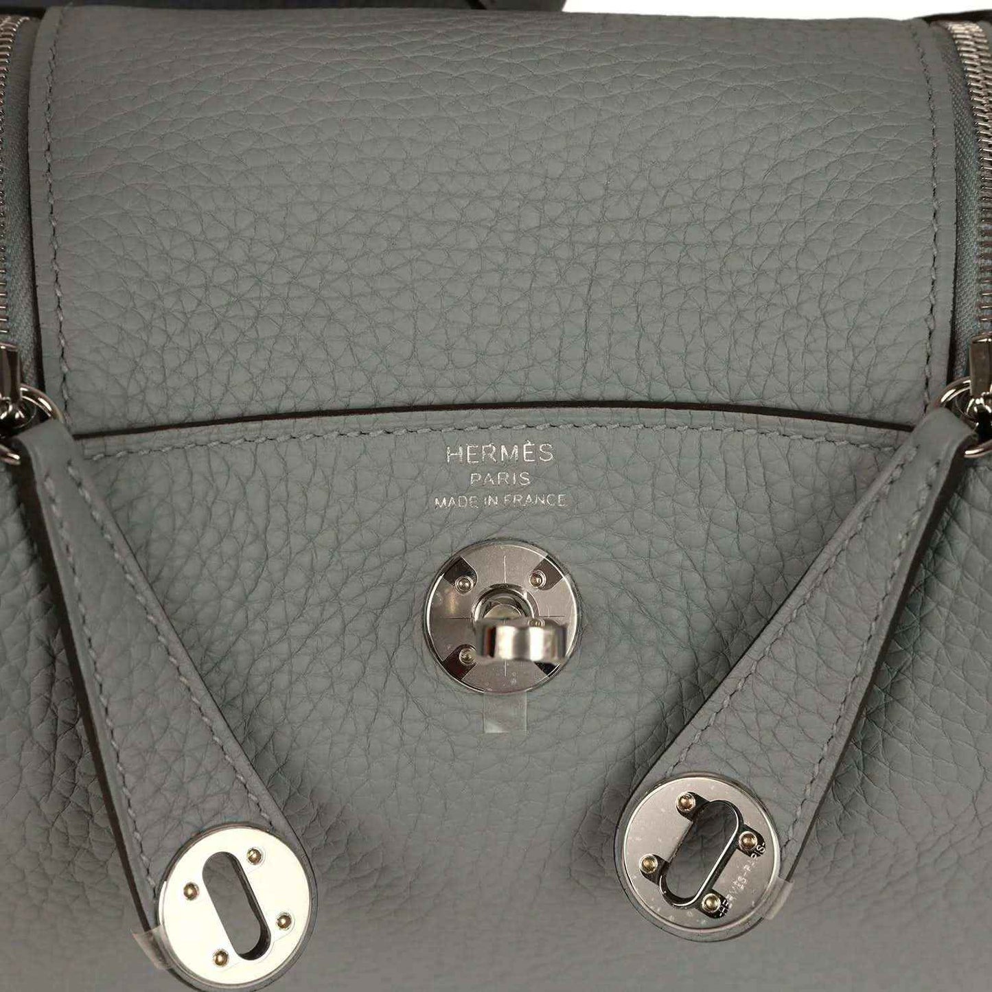 Hermes logo stamp and front turn-lock clasp on gray-green leather handbag