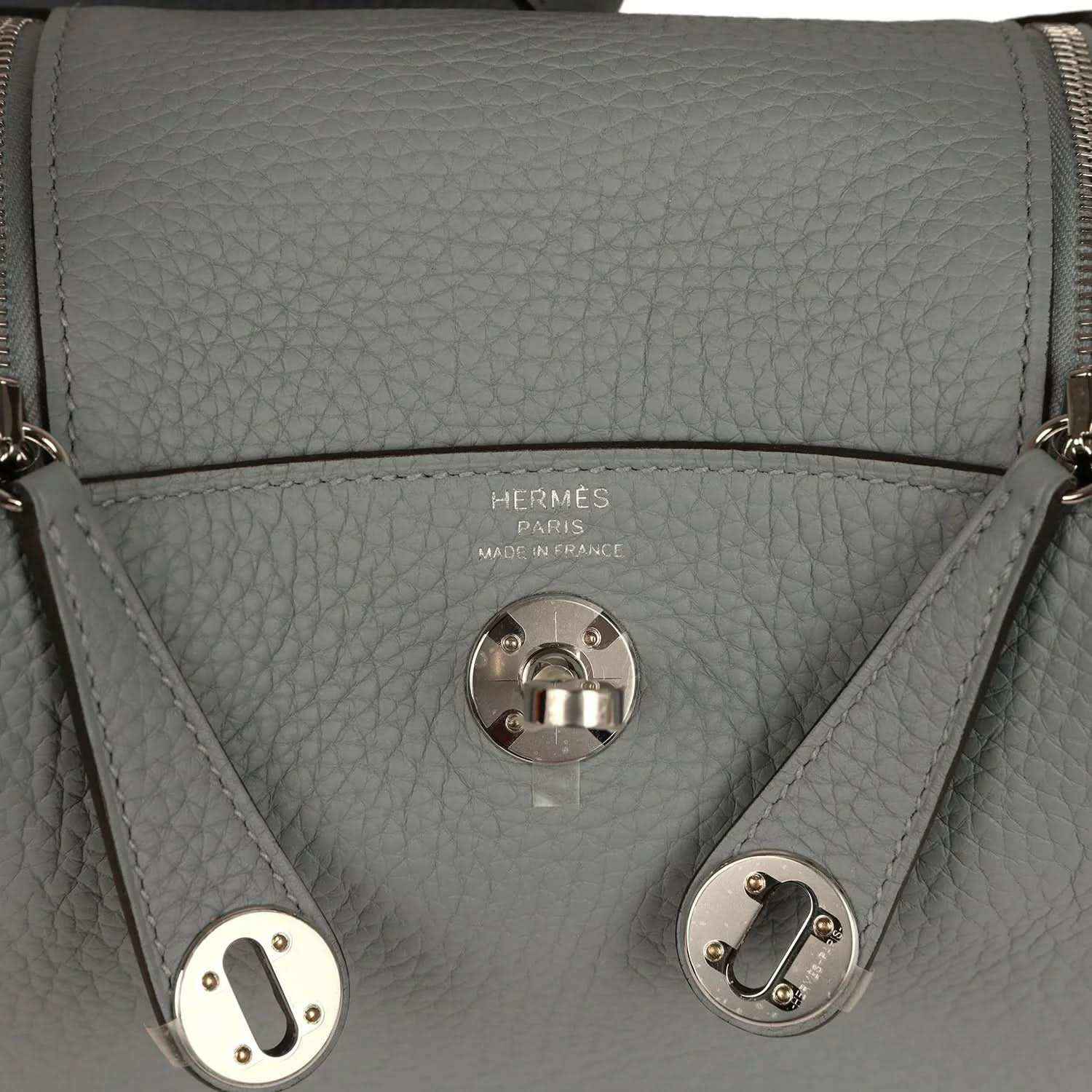 Hermes logo stamp and front turn-lock clasp on gray-green leather handbag