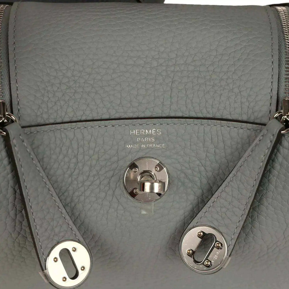 Hermes logo stamp and front turn-lock clasp on gray-green leather handbag