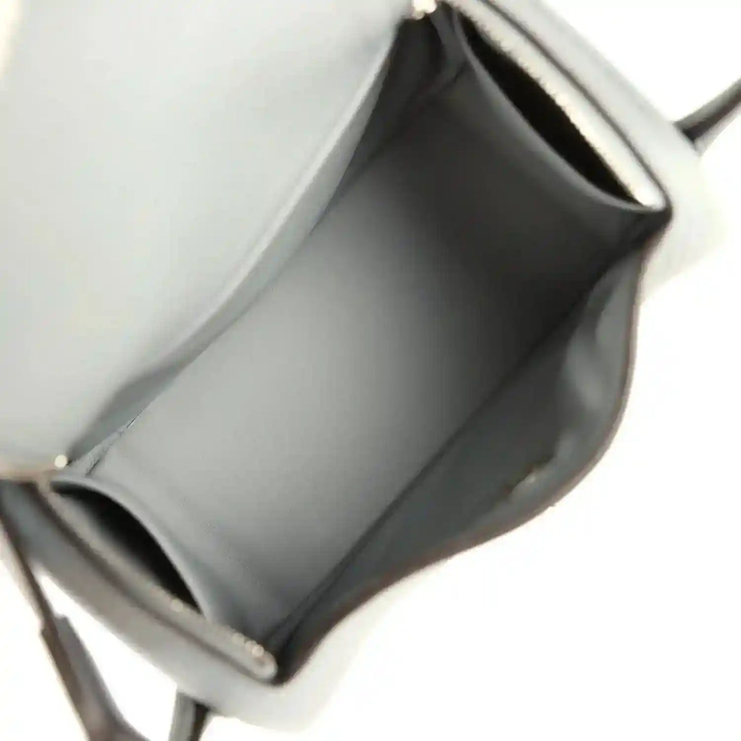 Mini leather handbag interior with smooth lining and stitched edges, gray tone