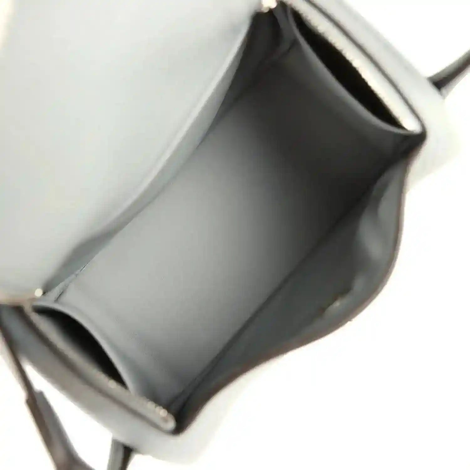 Mini leather handbag interior with smooth lining and stitched edges, gray tone